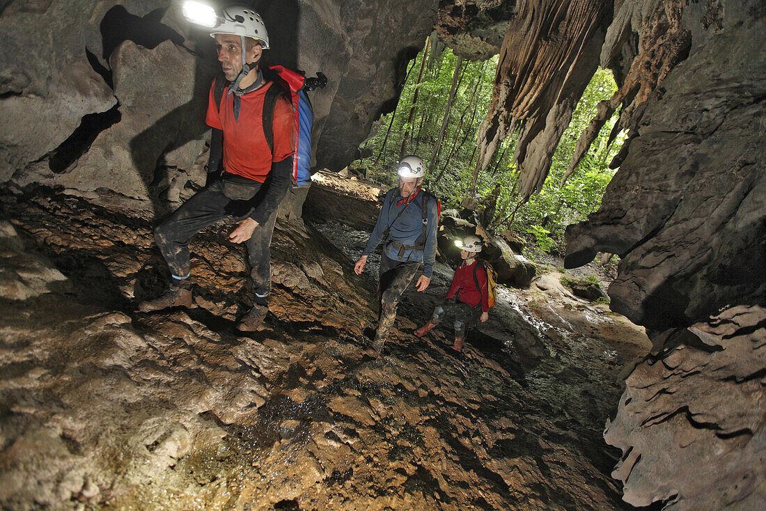 Cave explorers at the entrance to Racer Cave, deep in the rainforest of Mulu National Park, Sarawak, Borneo.