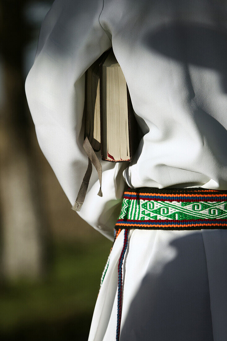 Detail of a bible that is under the arm of a priest who is wearing a traditional tarahumara belt in Guachochi, Chihuahua, Mexico.