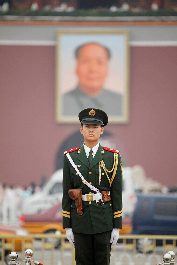 Soldier on guard on Tiananmen Square in Beijing in front of the Forbidden City and the big portrait of Mao Zedong