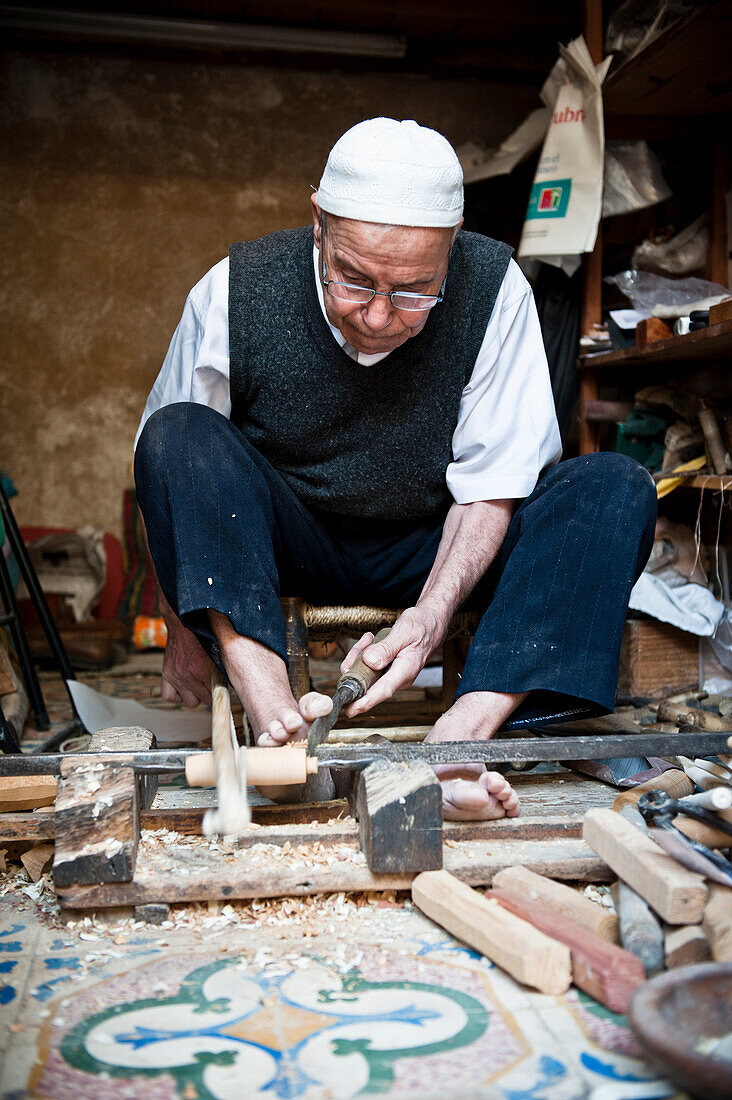 Local carpenter making wooden souvenirs in the streets or the old medina in Fez, Morocco