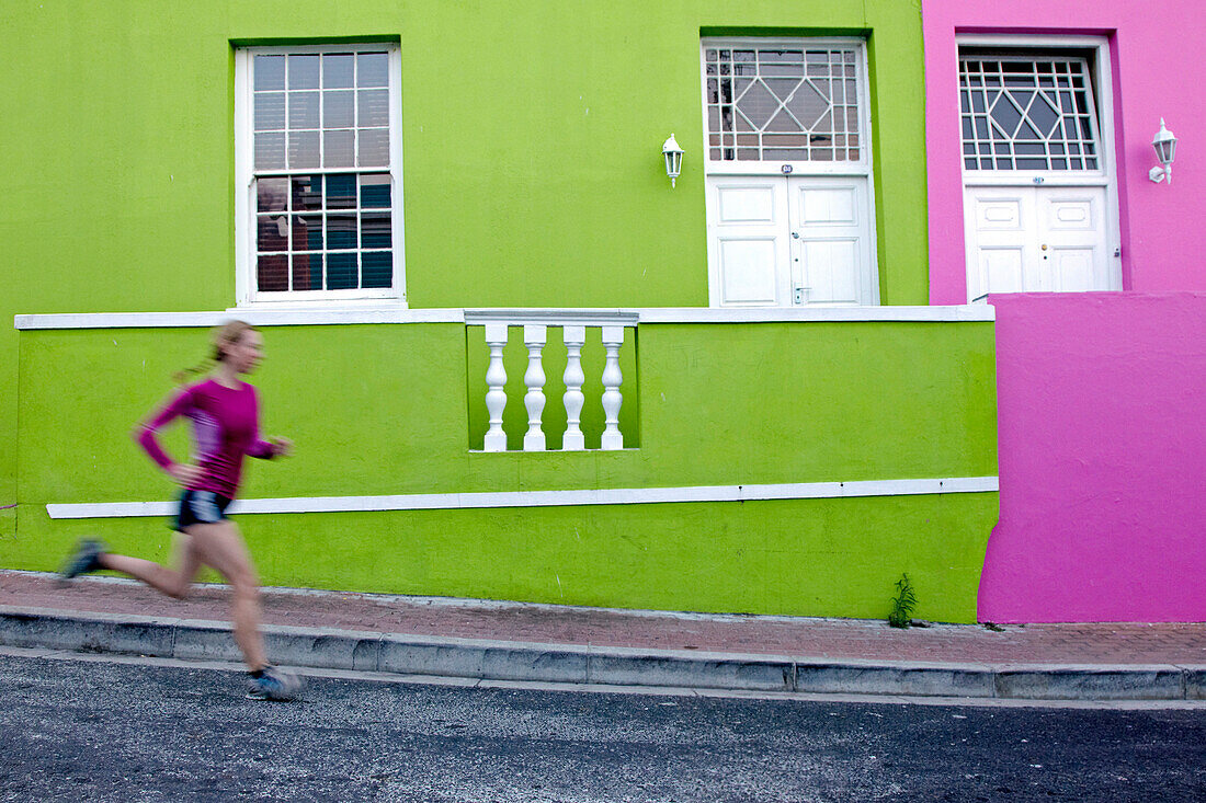 Katrin Schneider running trough the streets of the very colorful Bo-Kaap or Capa Malay Quarter of Cape Town. South Africa.