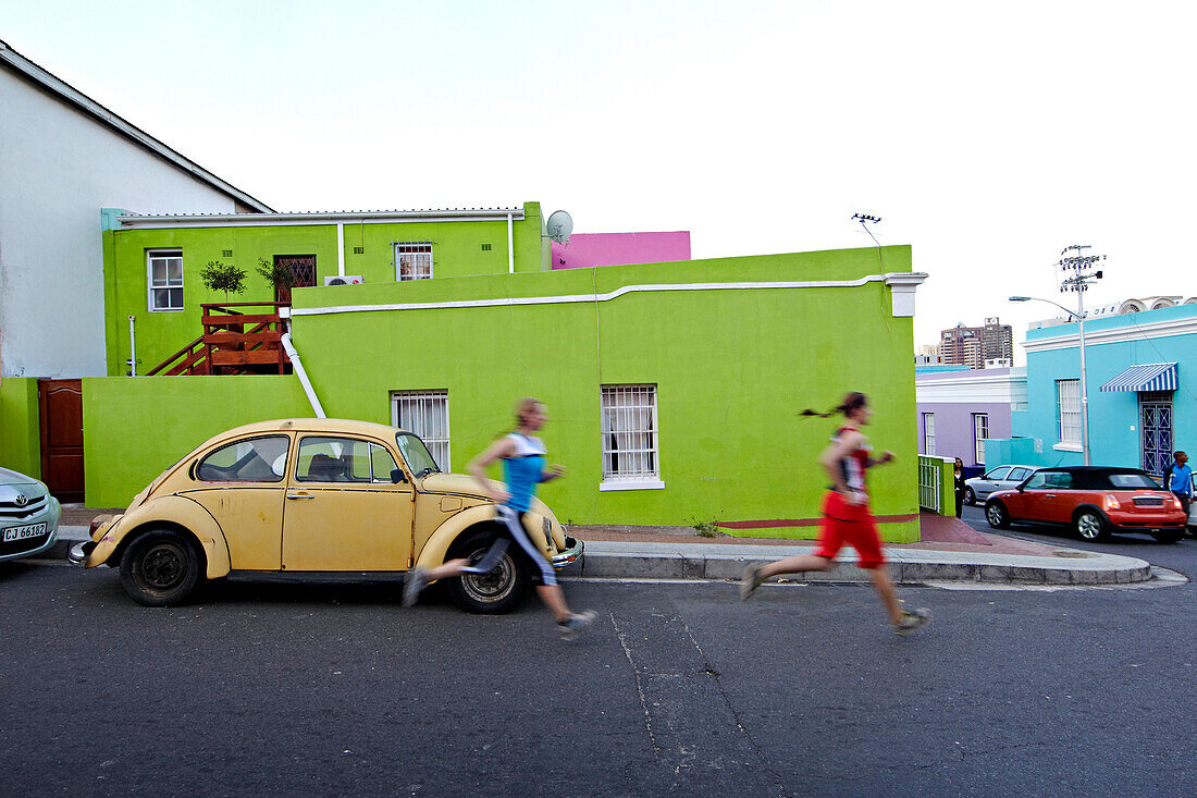 Katrin Schneider and Susann Scheller running trough the streets of the very colorful Bo-Kaap or Capa Malay Quarter of Cape Town. South Africa.