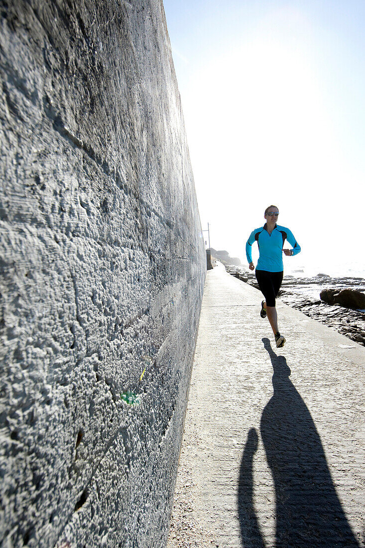 Susann Scheller running between St.James and Muizenberg on the shores of False Bay. Cape Town, South Africa.