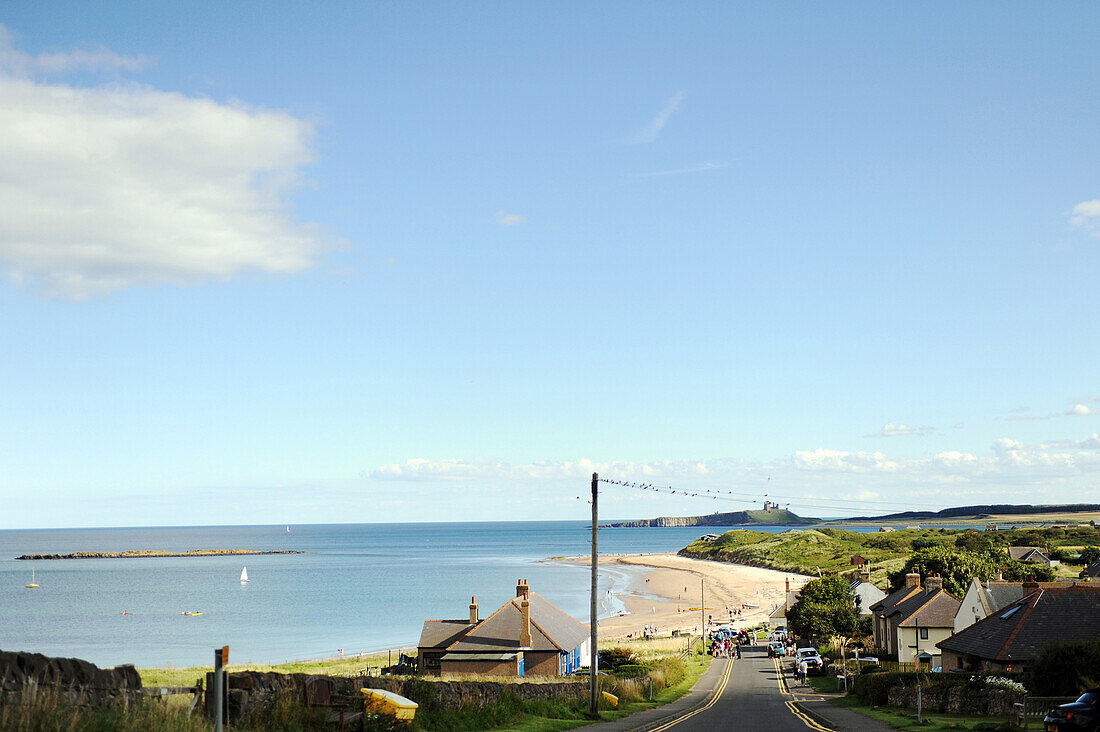 Late summer tourists flock to the Northumberland shoreline with castles in the distant horizon.