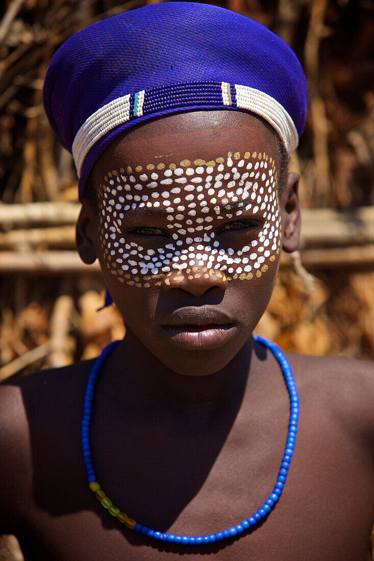 Boys from the Arbore tribe dot their faces with brightly colored paint. this is a very small tribe living in a harsh environment.Arbore tribe,Weyto valley,South Ethiopia, 2012