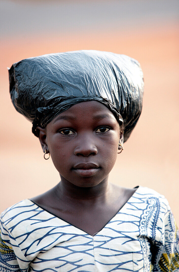 Young girl with plastic bag on her hair.