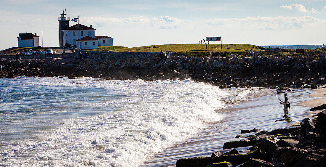 A Surf-casting fisherman, and the Watch Hill Lighthouse.