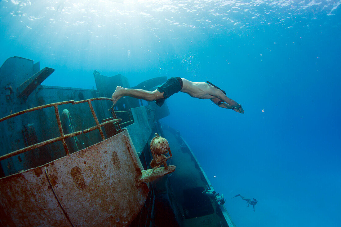 'A freediving man ''jumps'' off the side of the Kittiwake Shipwreck off Grand Cayman Island.'