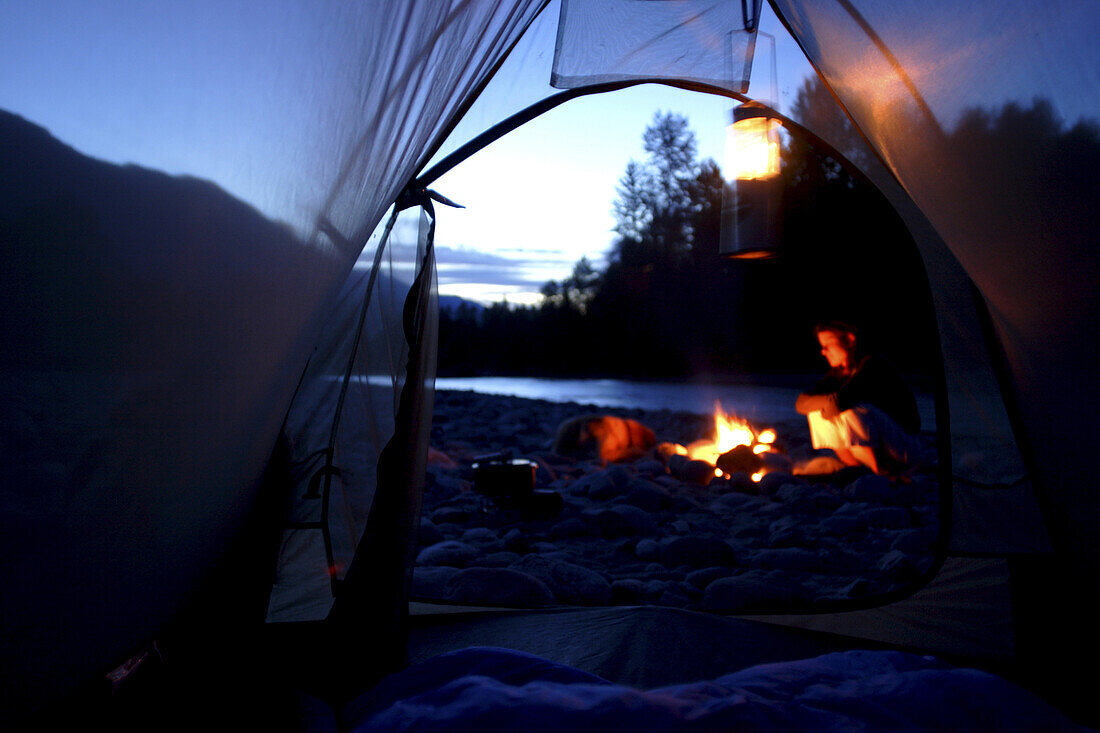 Nadine St Pierre camping along river near Squamish, BC, Canada.