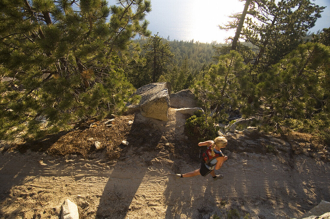 Katrin Griebeling running on the Flume Trail, high above Lake Tahoe view from above,. Nevada, USA.