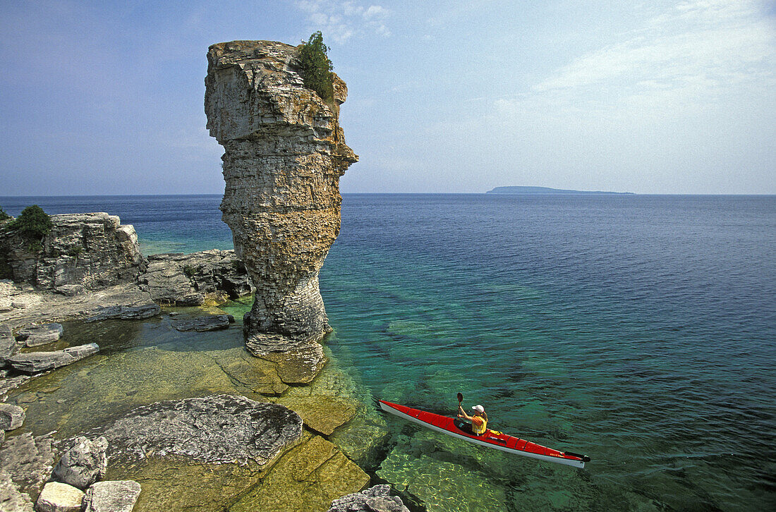 Bernadette Muhic-Georgi sea-kayaks past Flowerpot Island in Fathom Five National Marine Park, Georgian Bay, Lake Huron near Tobermory, Ontario, Canada. Photo by Henry Georgi/Aurora