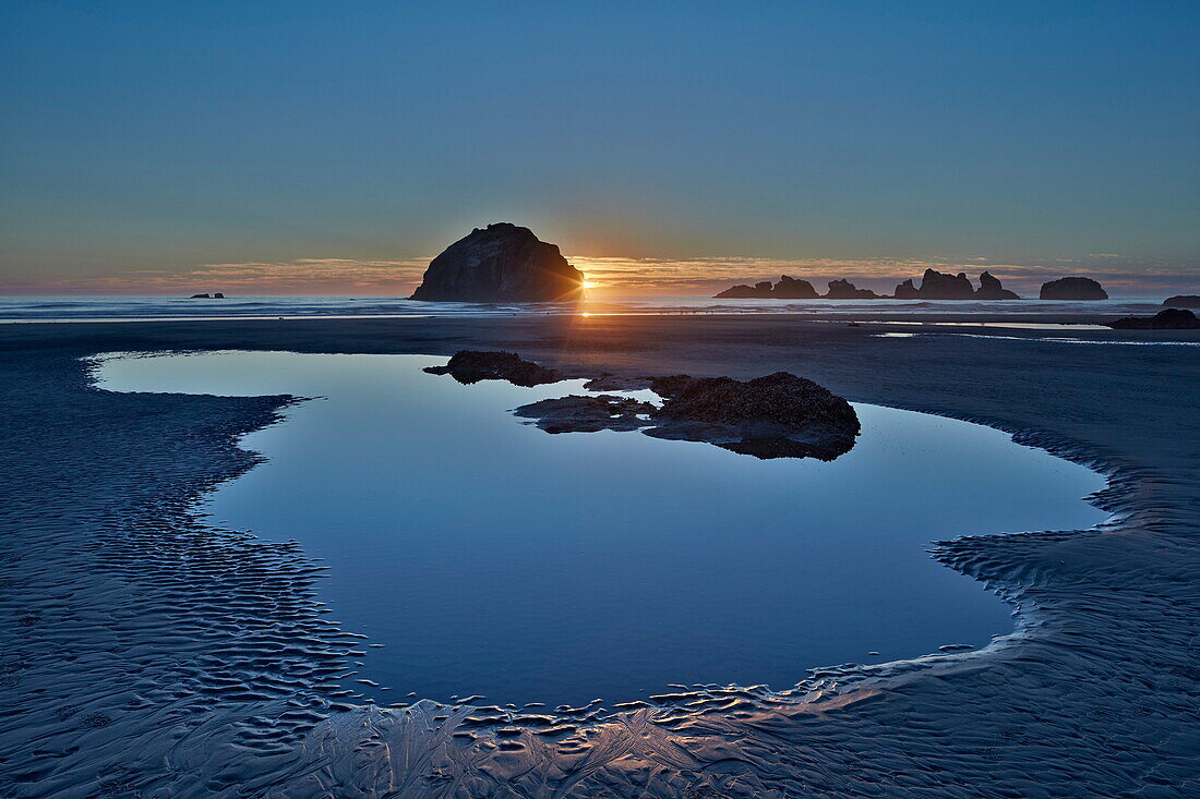 Sunset by a sea stack over a pool on the beach, Bandon Beach, Oregon, United States of America, North America