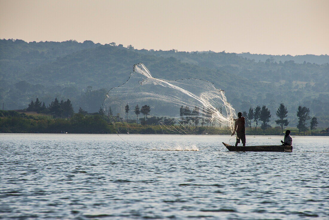 Local fisherman in a dug-out canoe in Jinja, Uganda, East Africa, Africa