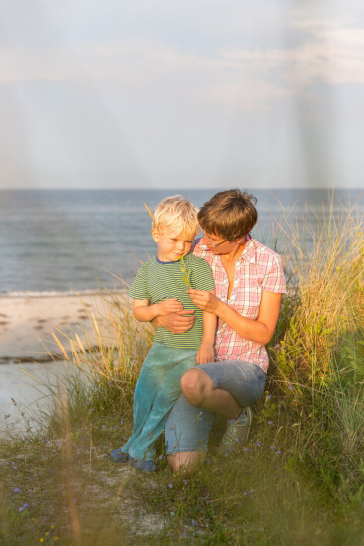 Mutter und Sohn (4 Jahre) im Dünengras am Ostseestrand, Marielyst, Falster, Dänemark