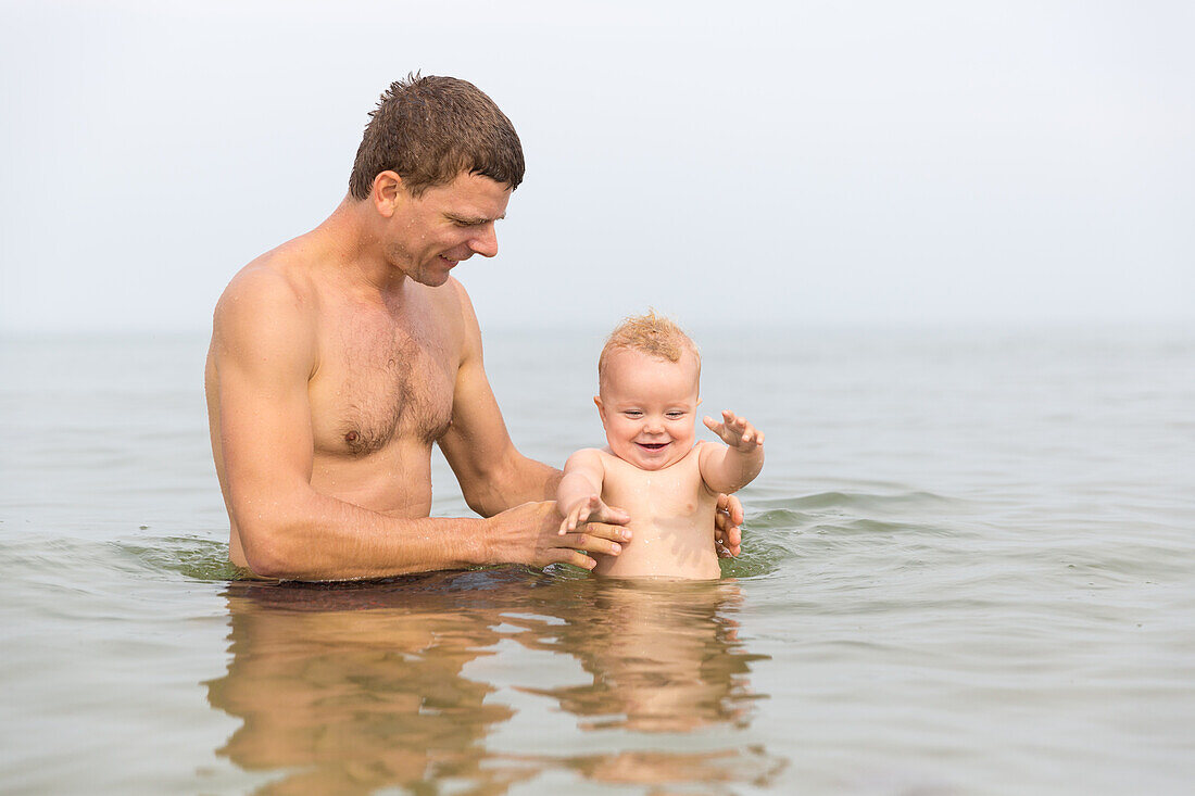 Vater und Tochter (1 Jahr) baden in der Ostsee, Marielyst, Falster, Dänemark