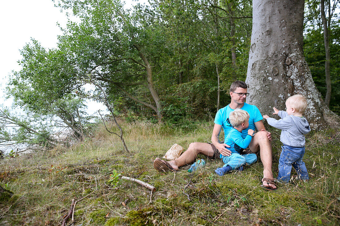 Vater und Kinder (1-4 Jahre) unter einem Baum, Stubbekobing, Falster, Dänemark
