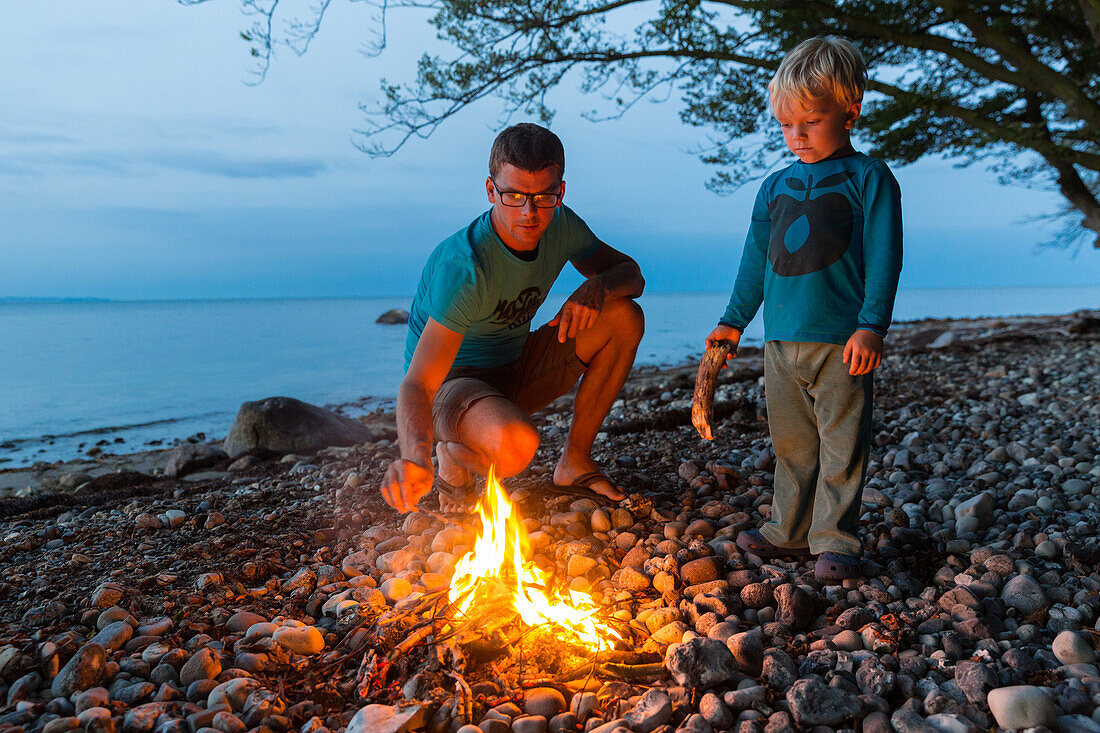 Father and son (4 years) at a campfire, Naesgaard, Falster, Denmark