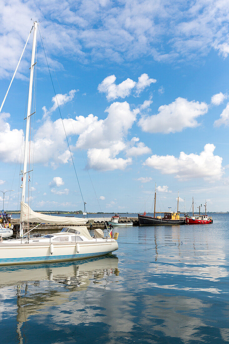 Sailing boat and fishing boats in harbor, Stubbekobing, Falster, Denmark