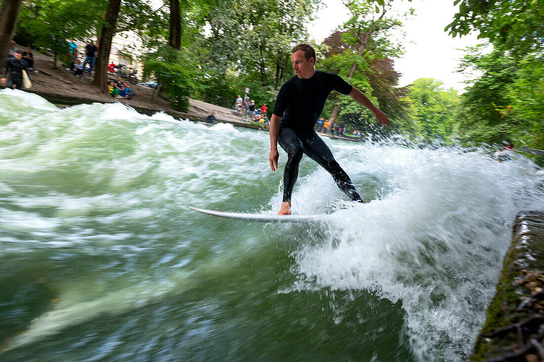 Surfer surfing on the Eisbach in the English Garden, Munich, Upper Bavaria, Bavaria, Germany