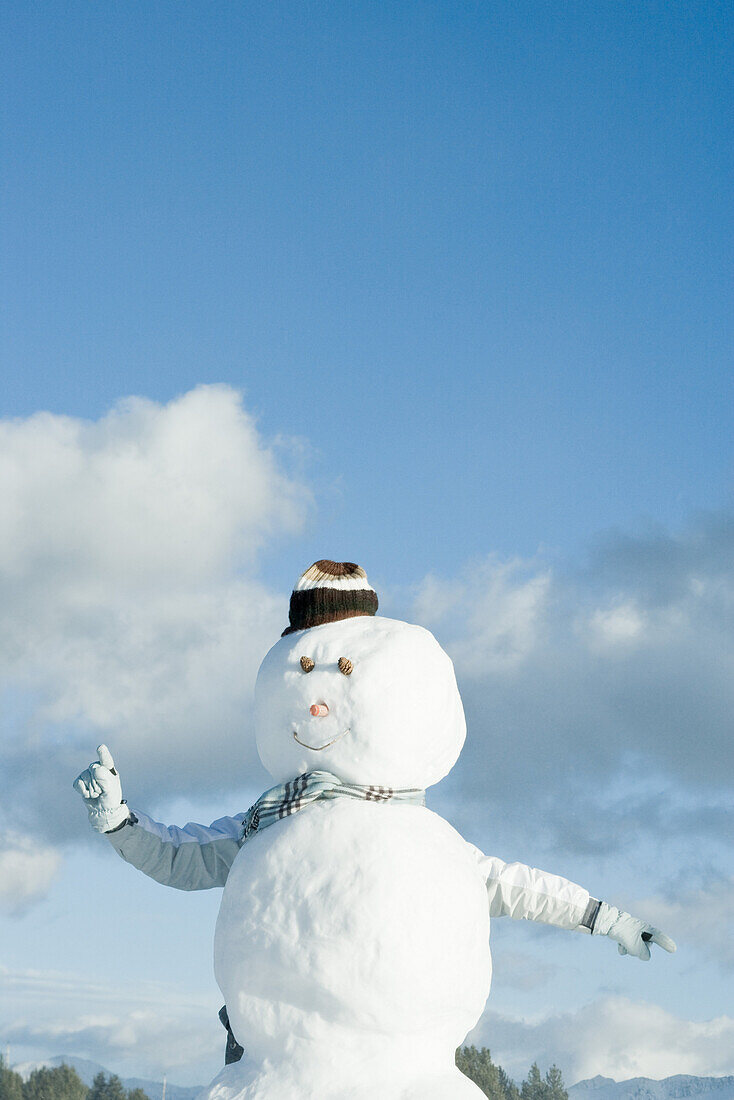 Person sticking arms out from behind snowman