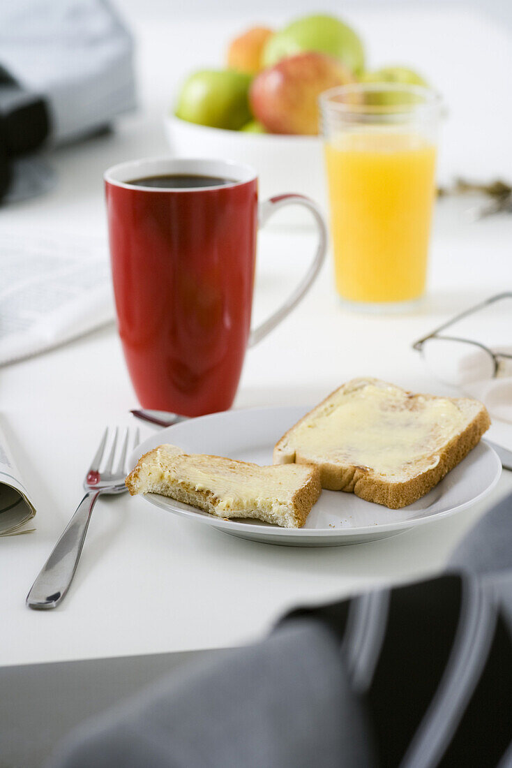 Breakfast consisting of buttered toast, coffee and orange juice