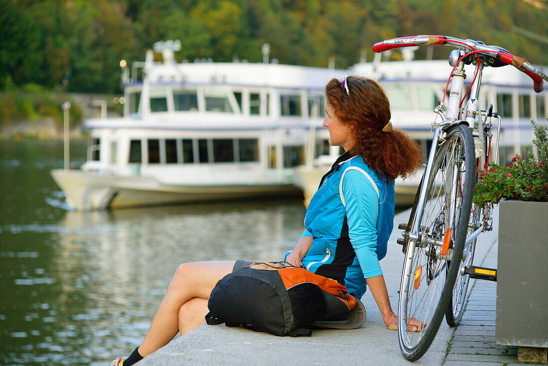 Cyclist resting at Danube riverbank, Passau, Lower Bavaria, Germany