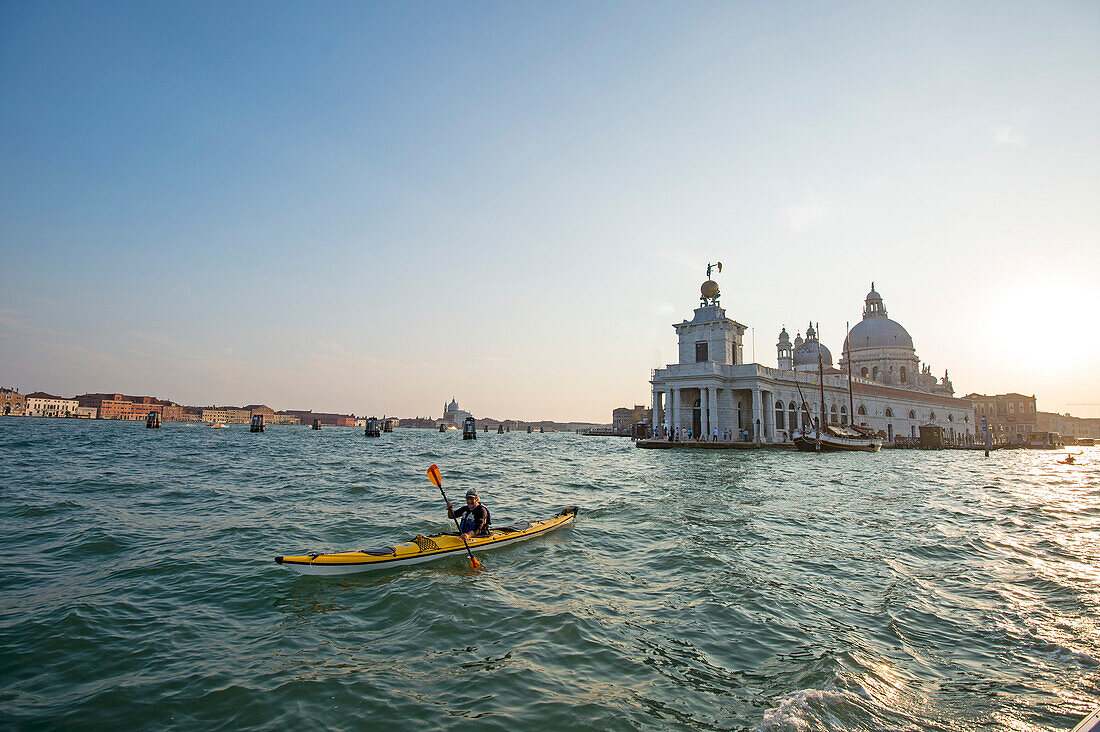 Paddler in front of historic church on Canal Grande, Venice, Italy