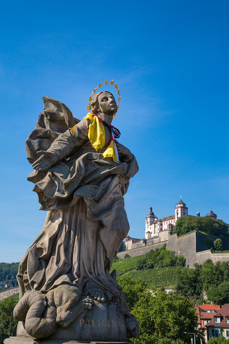 Statue mit Deutschland-Schal auf Alte Mainbrücke über Fluss Main mit Festung Marienberg im Hintergrund, Würzburg, Franken, Bayern, Deutschland