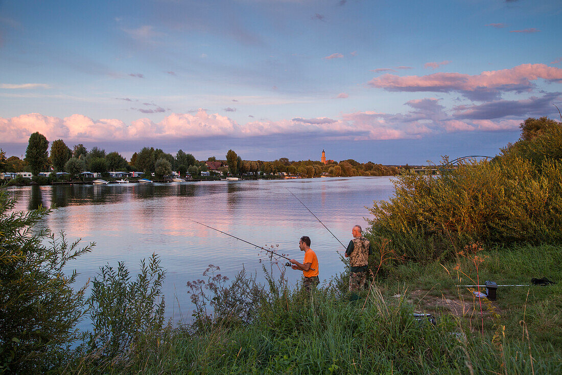 Zwei Angler am Ufer vom Fluss Main mit Campingplatz bei Sonnenuntergang, Volkach, Franken, Bayern, Deutschland