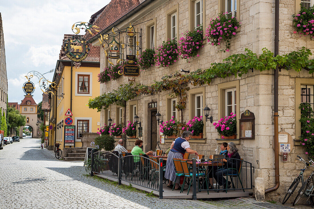 Menschen sitzen draußen vor dem Gasthaus Zum Goldenen Ochsen in der Altstadt, Sommerhausen, nahe Ochsenfurt, Franken, Bayern, Deutschland