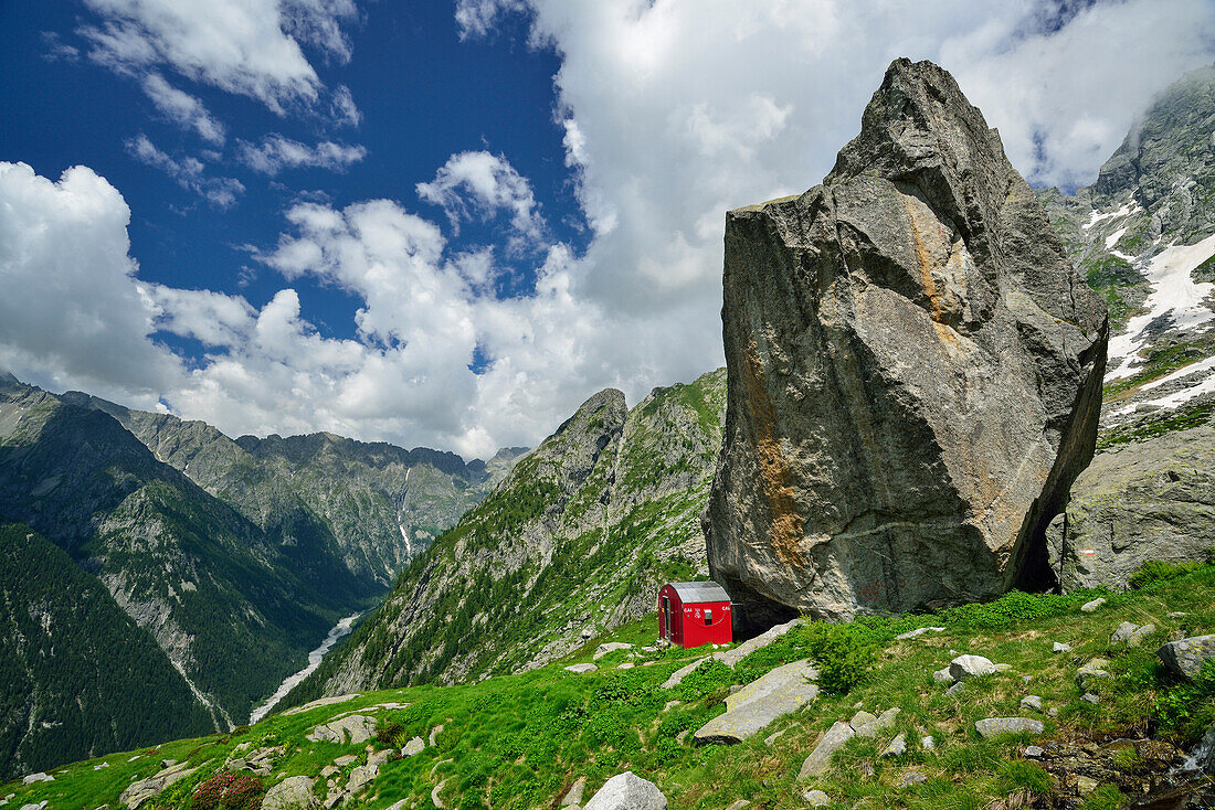 Rote Biwakschachtel unter Felsblock, Lombardei, Italien