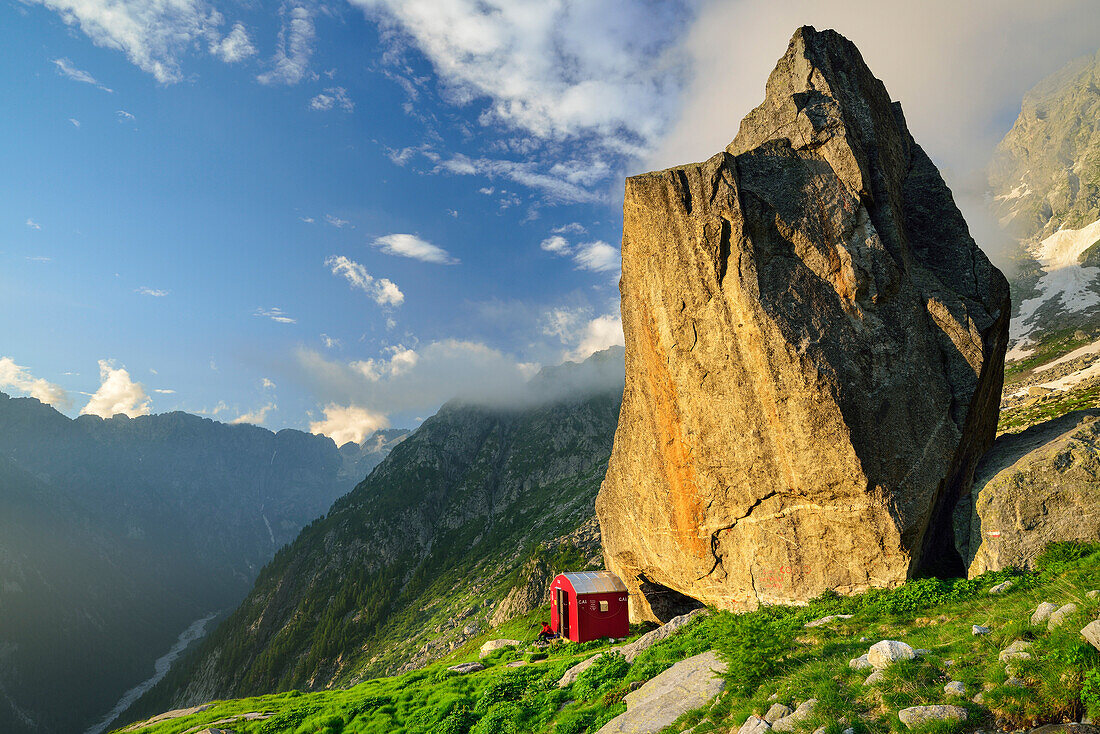 Rote Biwakschachtel unter Felsblock, Lombardei, Italien