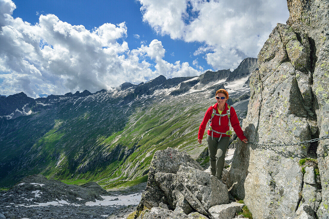 Woman climbing on fixed-rope route, Sentiero Roma, Bergell range, Lombardy, Italy