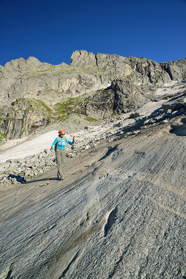 Woman hiking on rock slab, Sentiero Roma, Bergell range, Lombardy, Italy