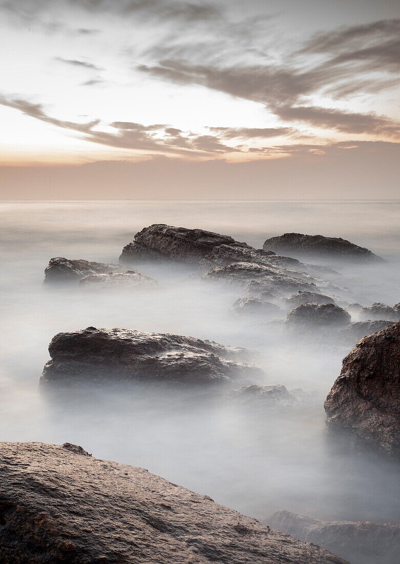 Long exposure of surf and rocks at sunrise, Tangalle, Sri Lanka, Indian Ocean, Asia