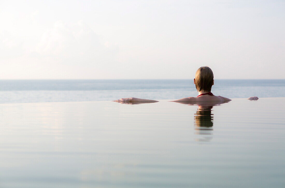 Woman in an infinity pool looking out to sea, Koh Samui, Thailand, Southeast Asia, Asia