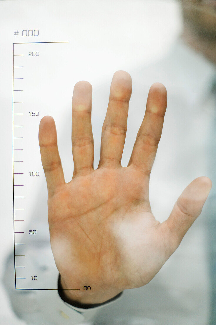 Man holding hand up to ruler