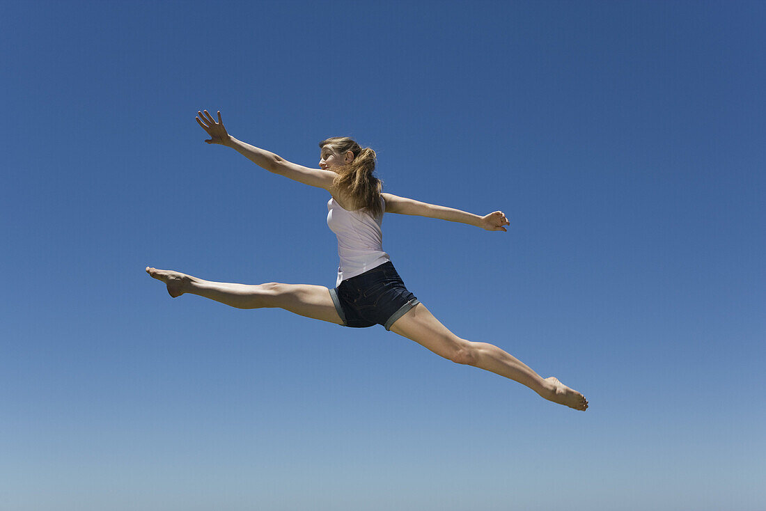 Young woman leaping, midair
