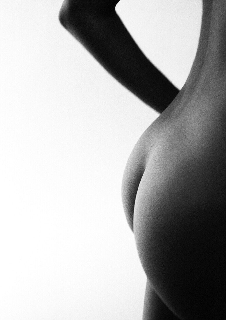 Woman's bare buttocks and lower back, side view, B&W