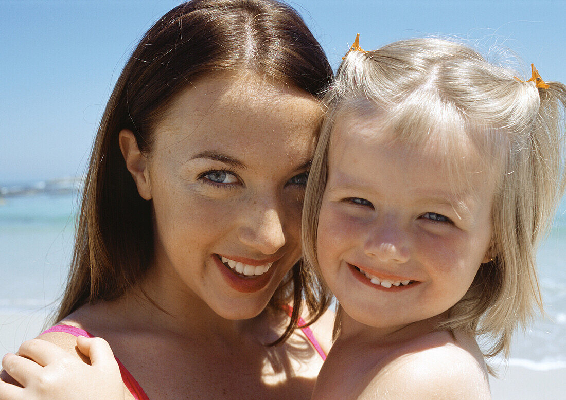 Young woman and child at the beach, close-up