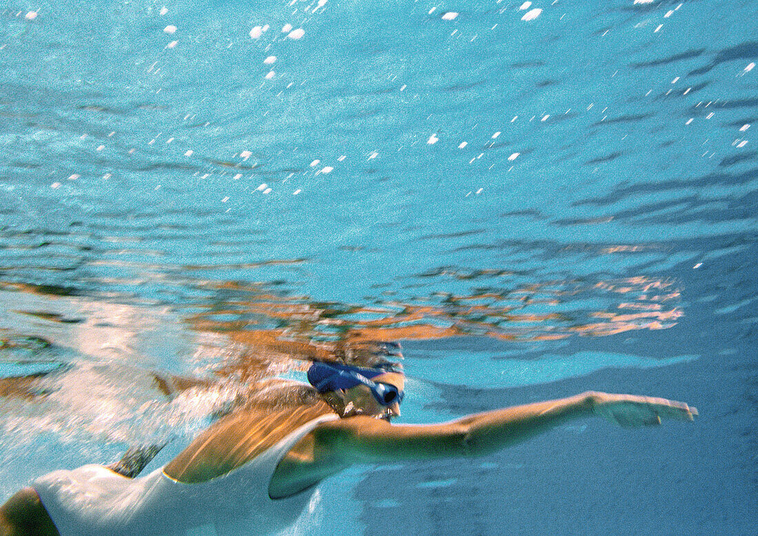 Woman swimming underwater, underwater view.