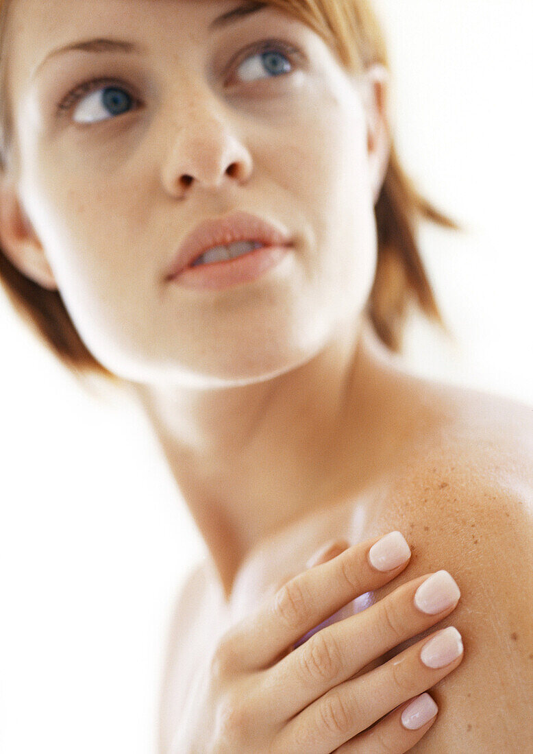 Woman with hand on shoulder, close-up