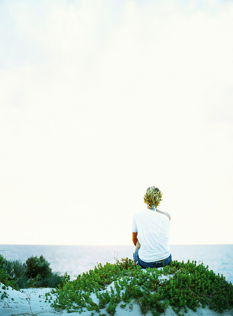 Woman looking out to sea, rear view