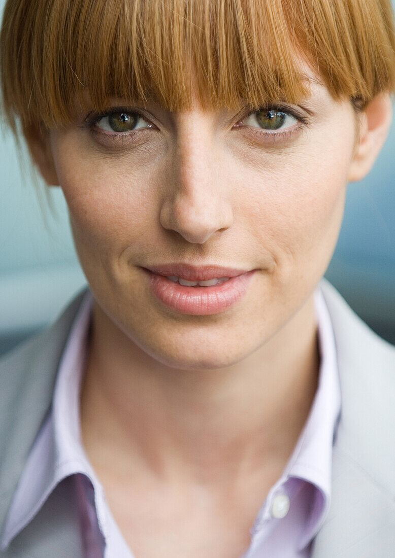 Woman with bangs smiling, portrait