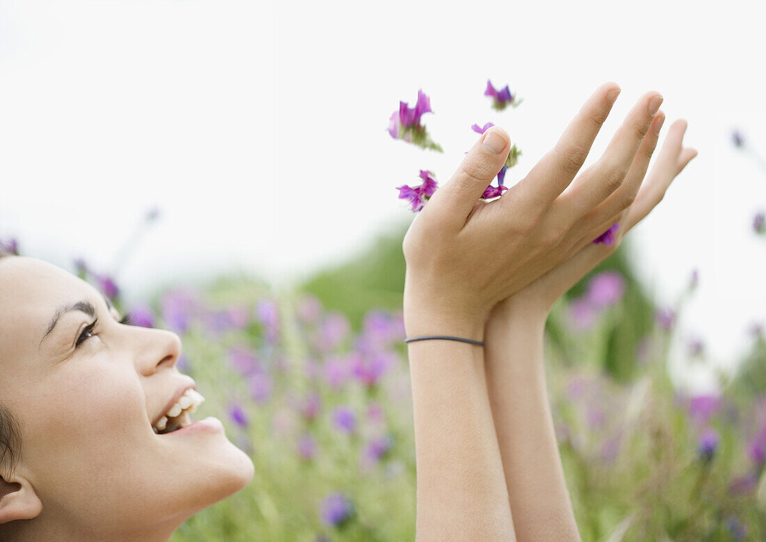 Young woman holding up flowers