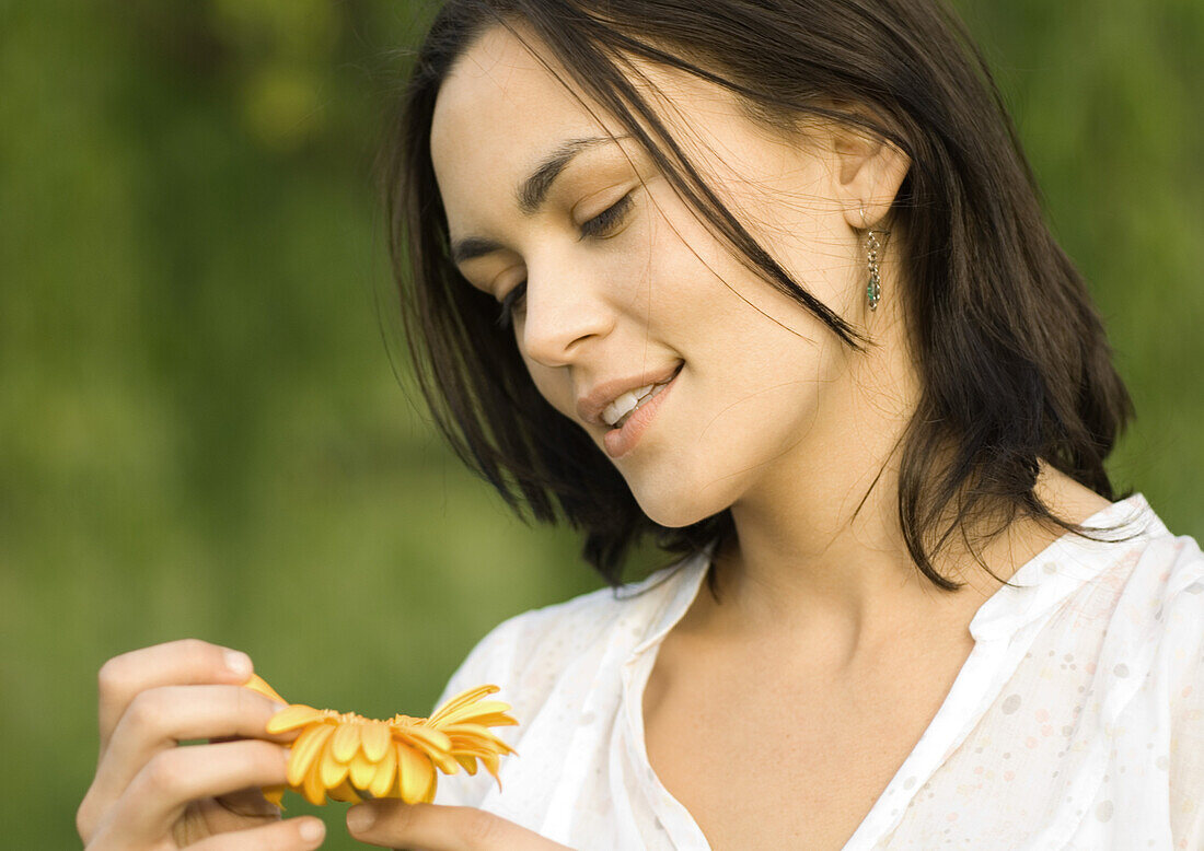Woman plucking petals from flower