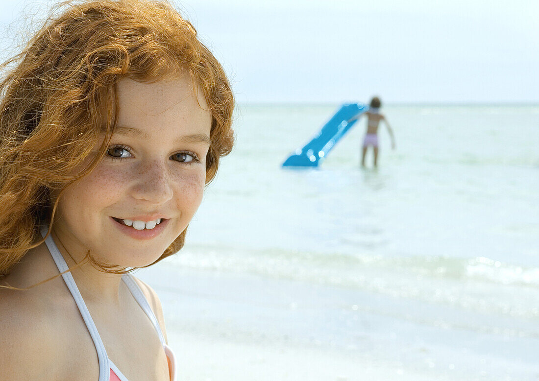 Girl smiling, ocean in background