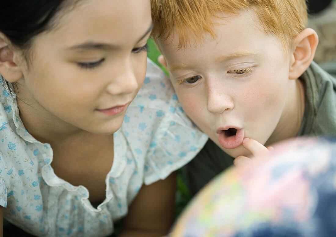 Children looking at globe together