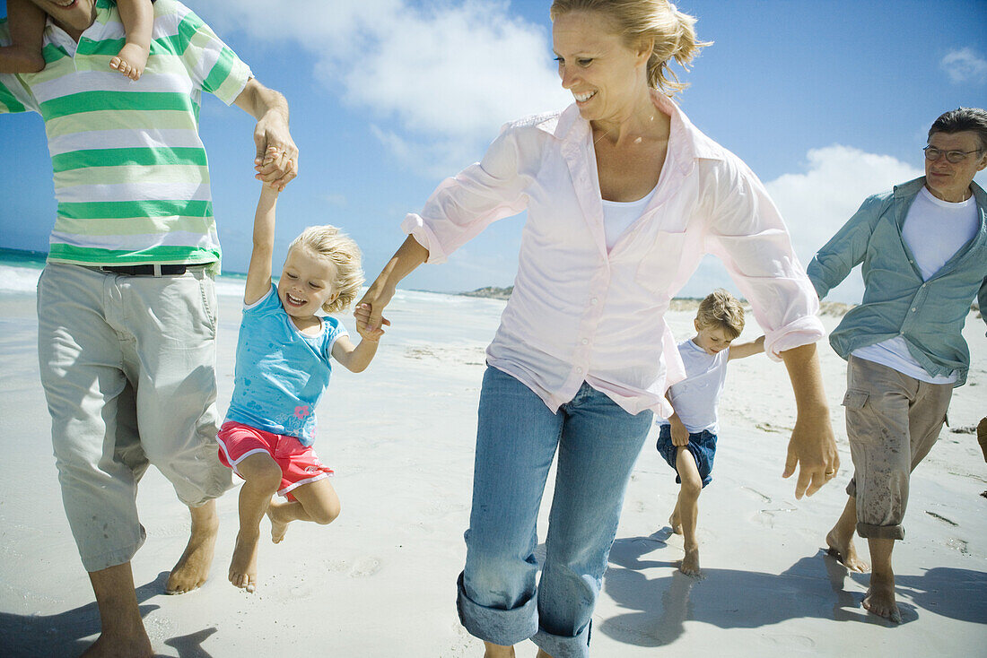 Three generation family walking on beach