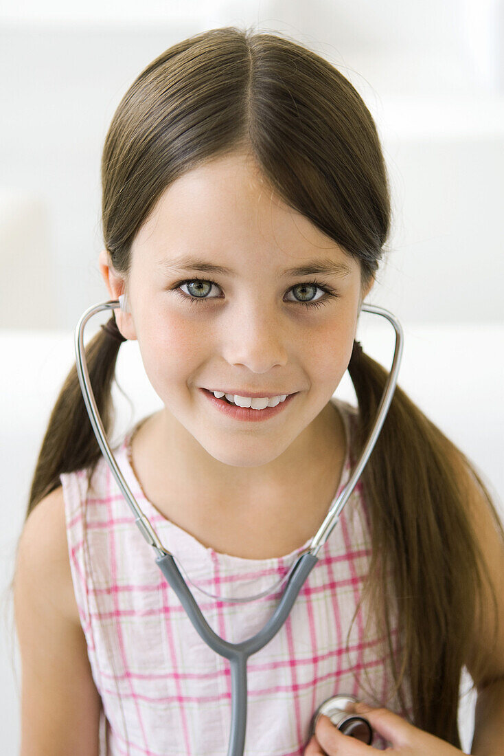 Girl listening to her own heart through stethoscope